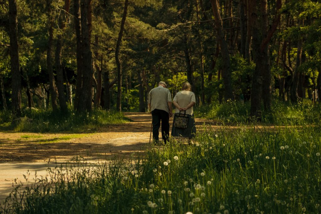 Elderly couple walking along a forest path